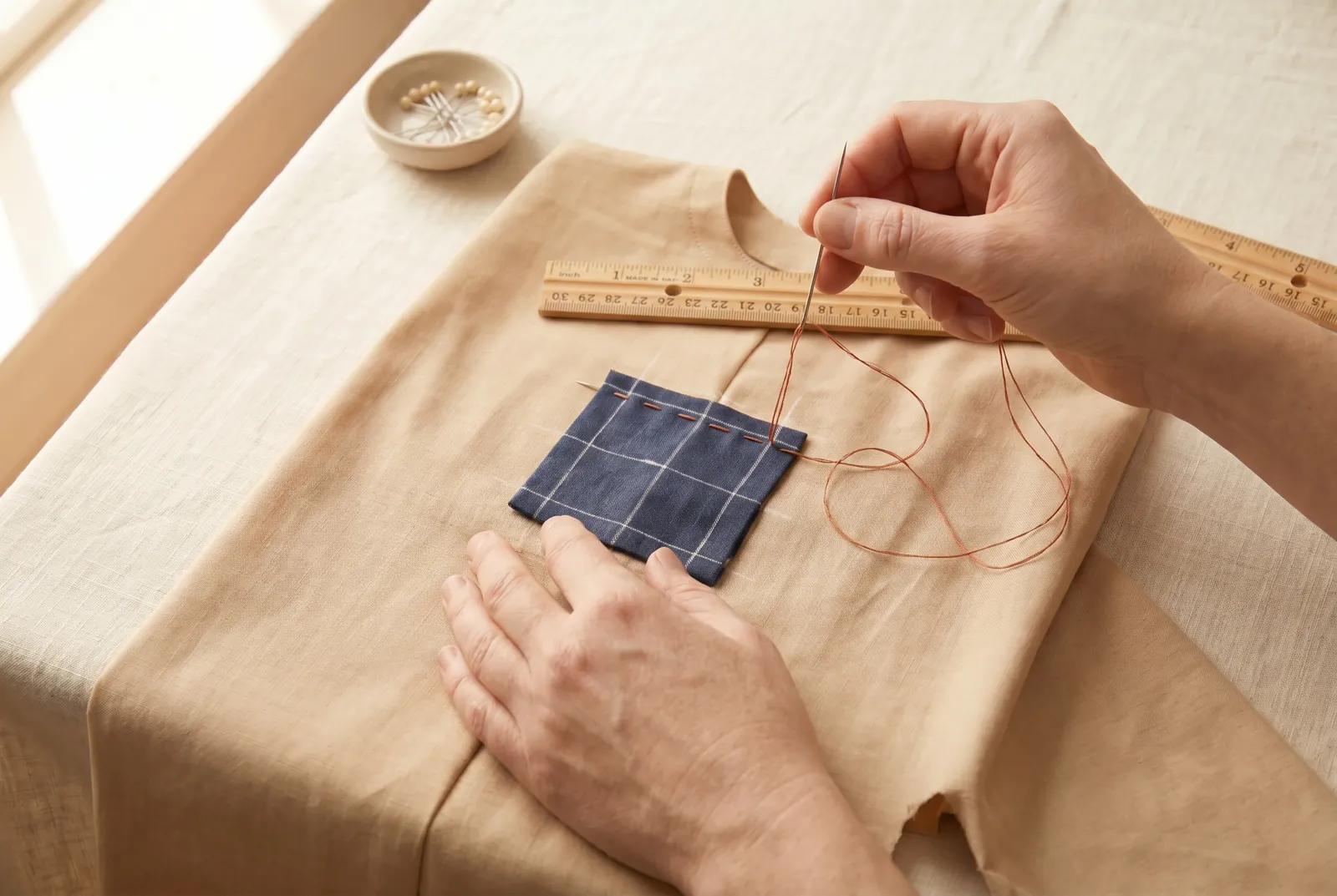 Photo: Thread the long needle with strong, soft cotton in a contrasting color and work rows of running stitch along the chalk lines, through all the layers.
