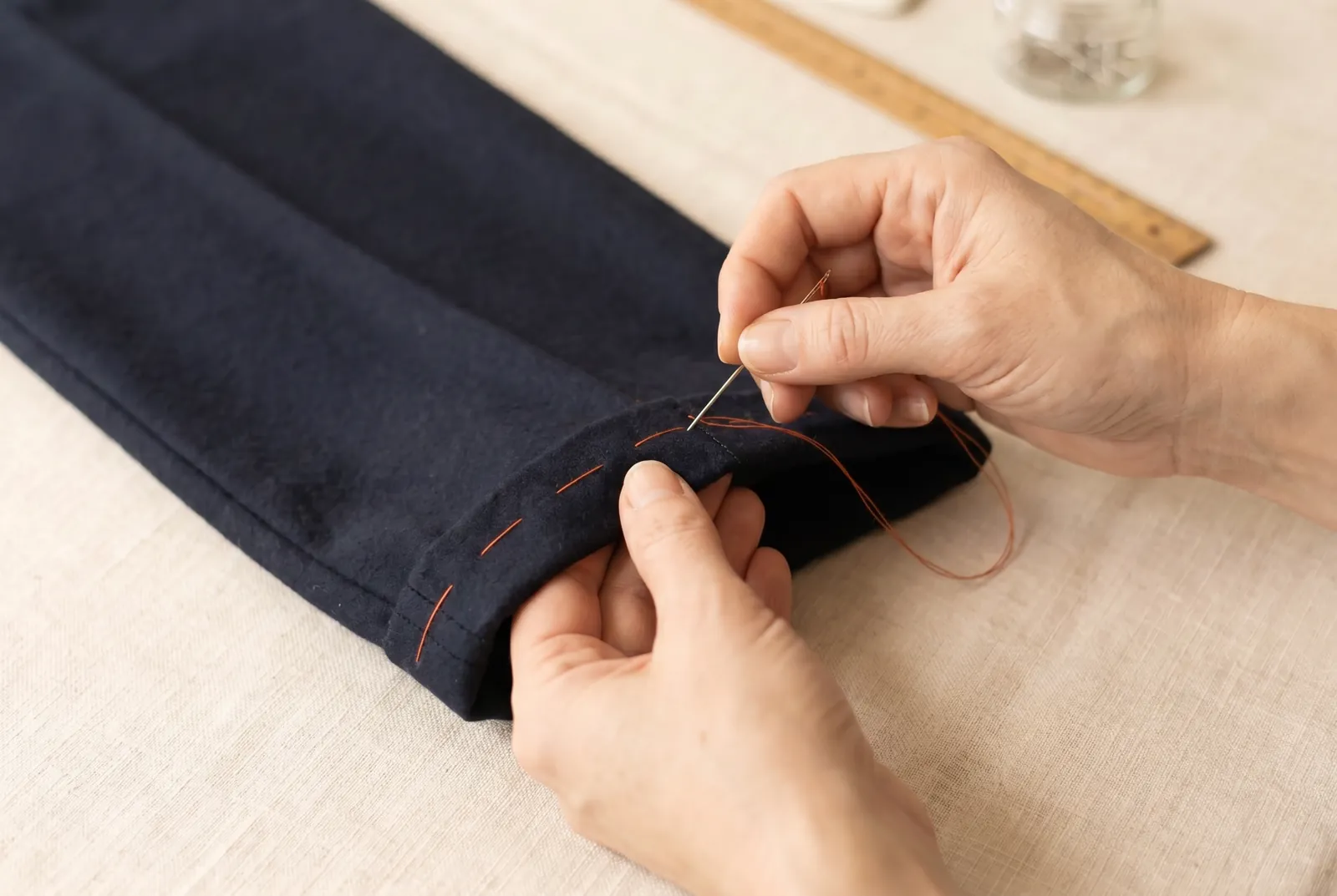 Photo: Sew the hem down with the hemming stitch, working from right to left with the hem lying across your left forefinger.