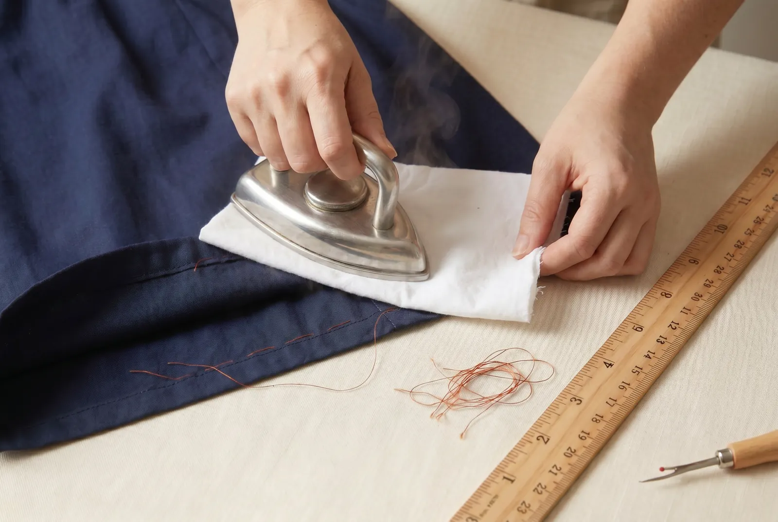 Photo: Lay the damp pressing cloth over the old crease and press on the wrong side until the fold line disappears.