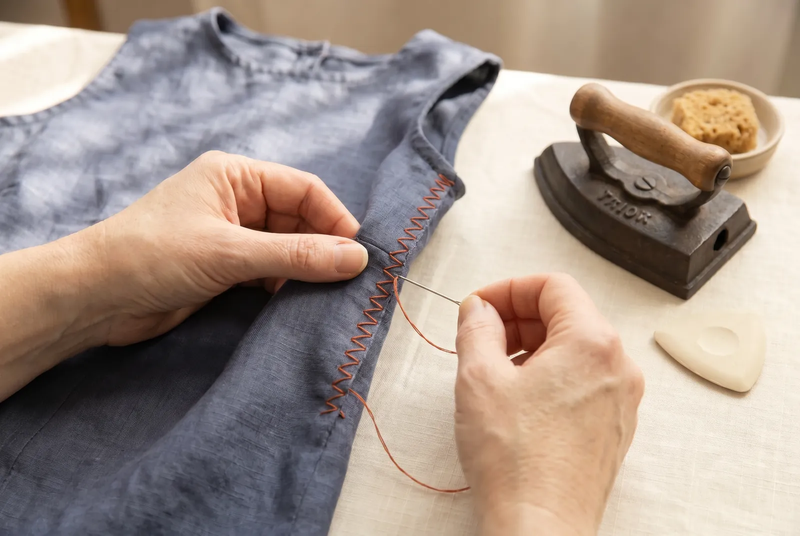 Photo: Finish the raw edges of the seam allowance with overcasting — slanting stitches about 3 mm (1/8 in) deep, evenly spaced — so they will not ravel, then press th…