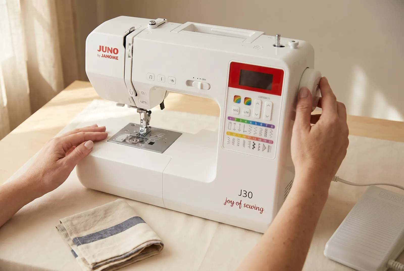 Photo: Find the handwheel at the right end of the machine — the large dial that moves the needle up and down.