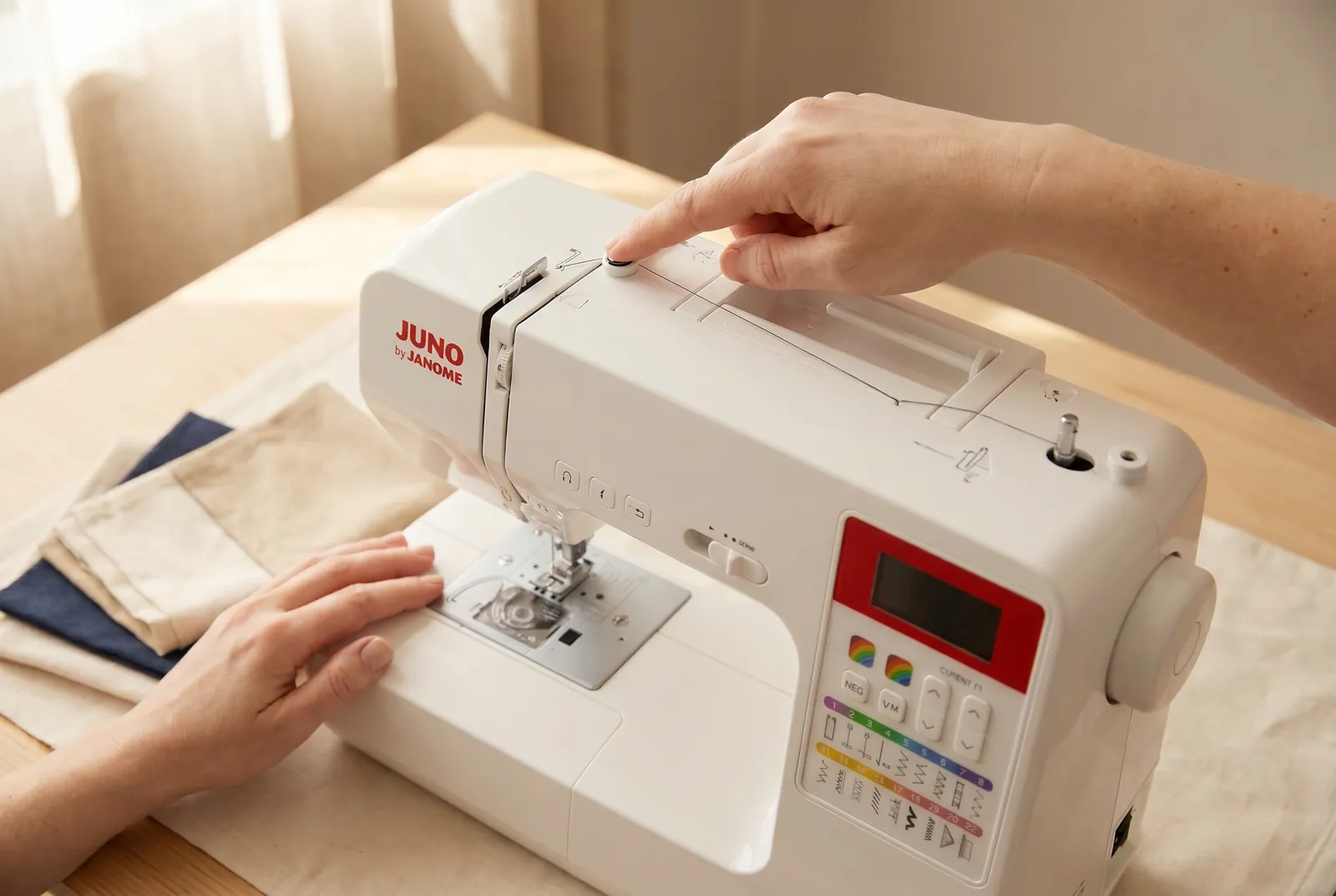 Photo: Find the spool pin on top of the machine, where a spool of thread sits, and trace the printed thread-guide path that runs from the pin down toward the needle.