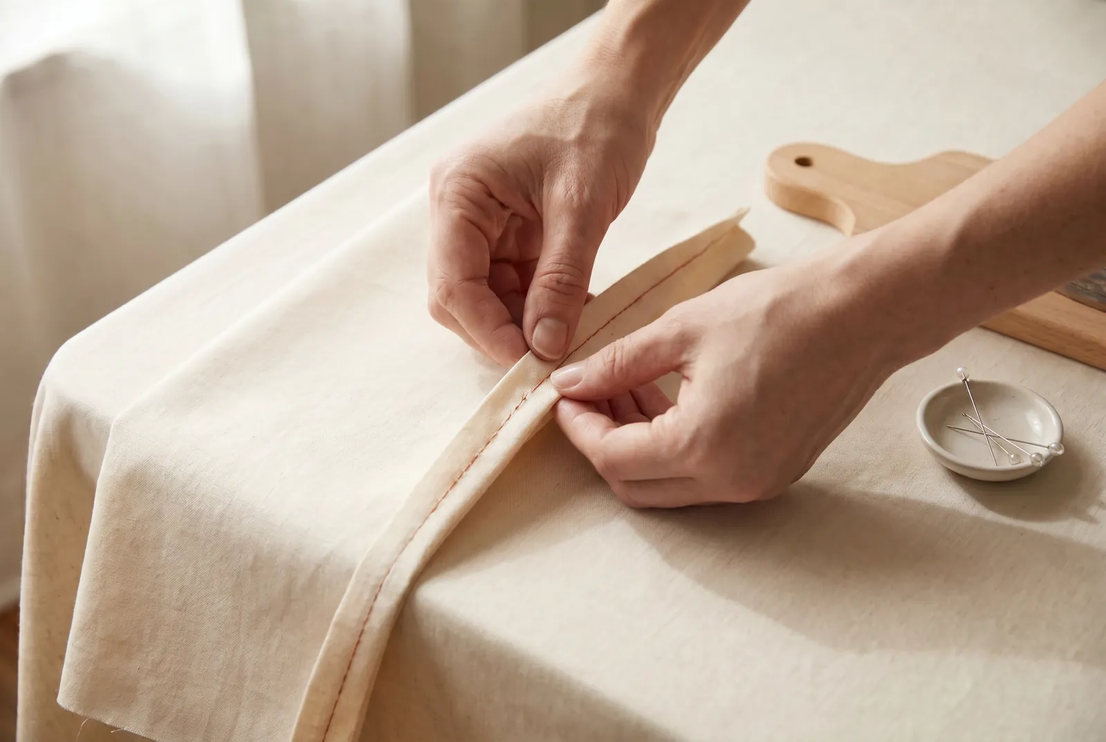 Photo: Turn the work so the right sides now come together, and roll the seam between your fingers until the first stitching lies exactly on the fold.