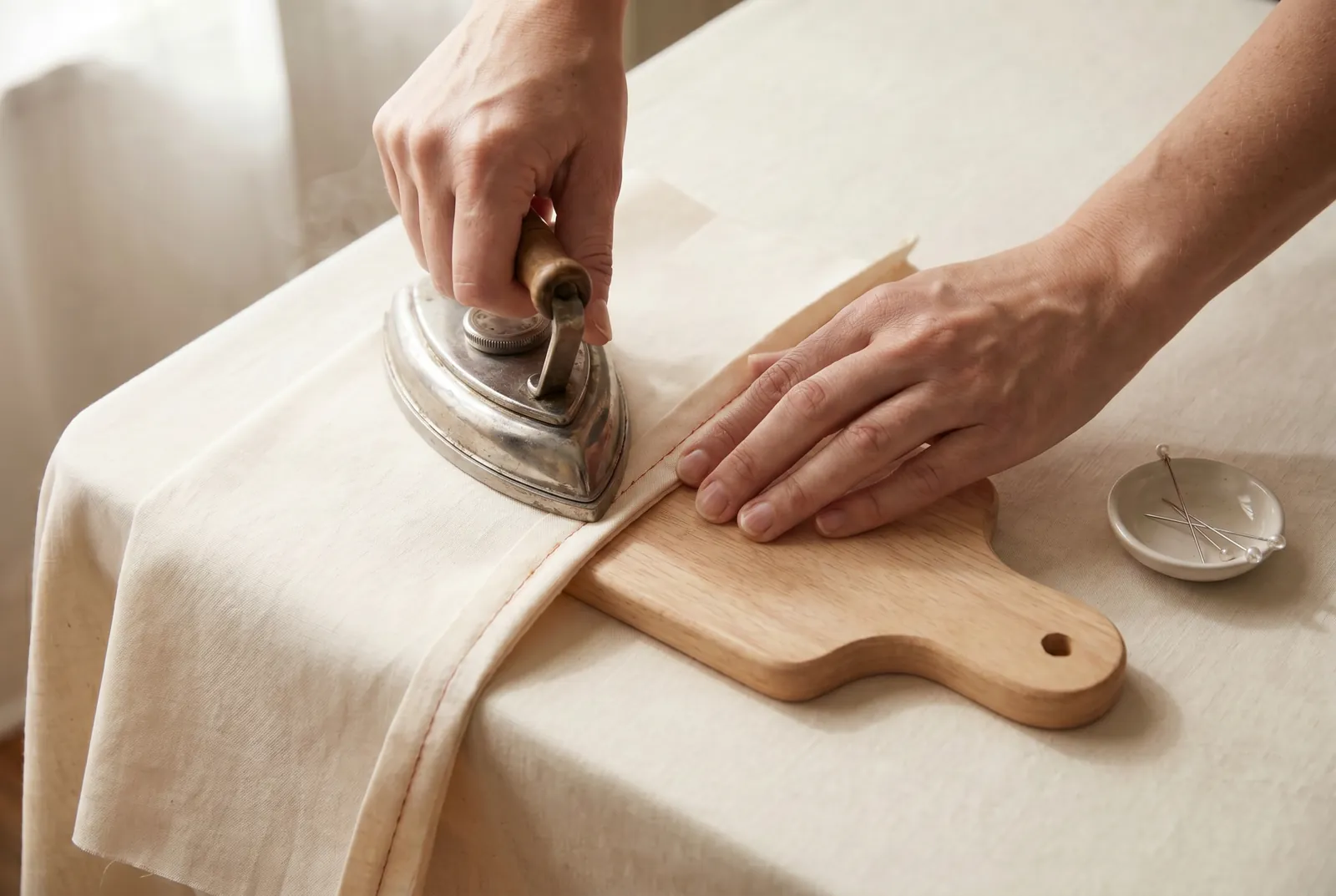 Photo: Press the fold flat along the stitching line before the second row crosses it — a seam once crossed can never afterward be pressed flat.