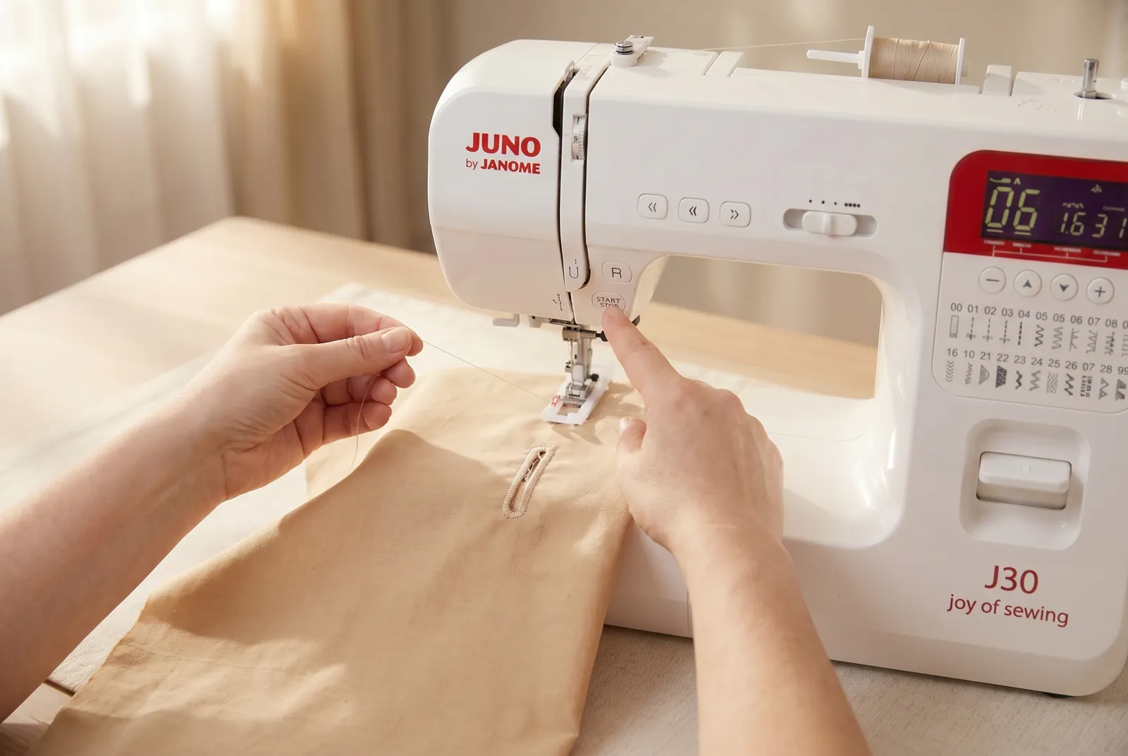 Photo: Hold the top thread tail clear with one hand and press start/stop (or press the foot pedal).