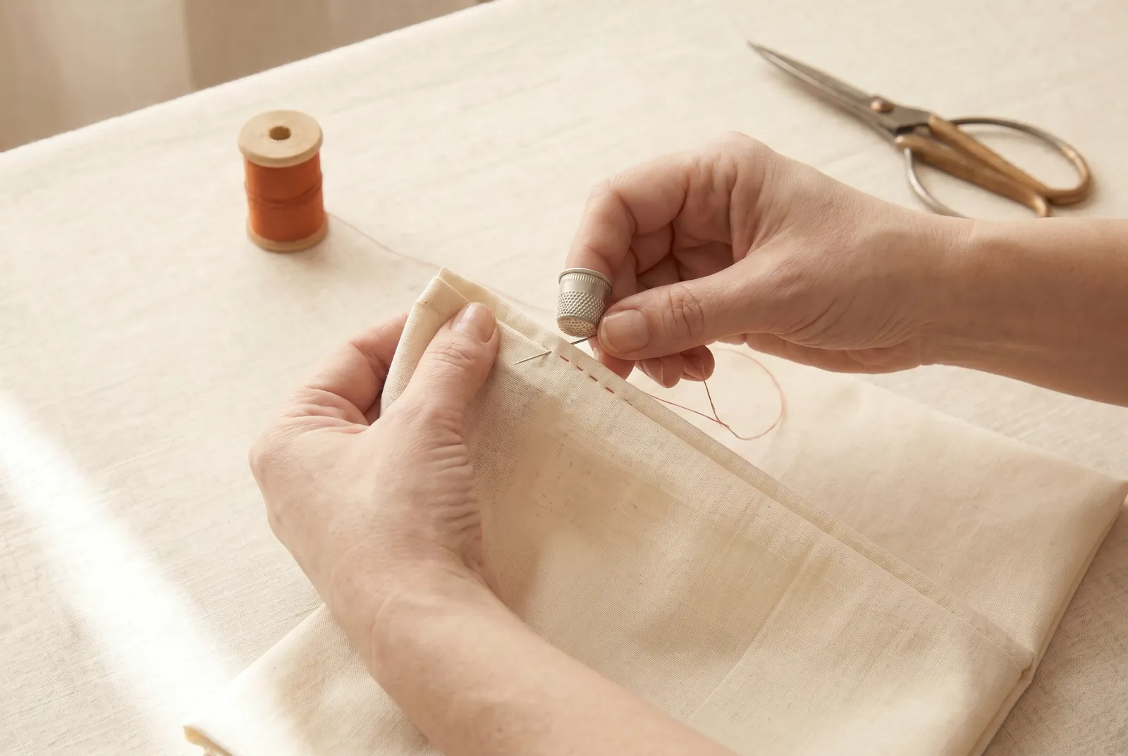 Photo: Finish the two 4 cm (1 1/2 in) gaps left open at the top of each seam by turning their raw edges under narrowly and hemming them flat.