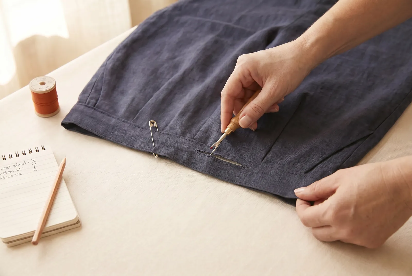 Photo: At each side-seam pin, use a seam ripper to pick out about 2.5 cm (1 in) of stitching from the inner layer of the waistband, opening the hollow channel at thos…
