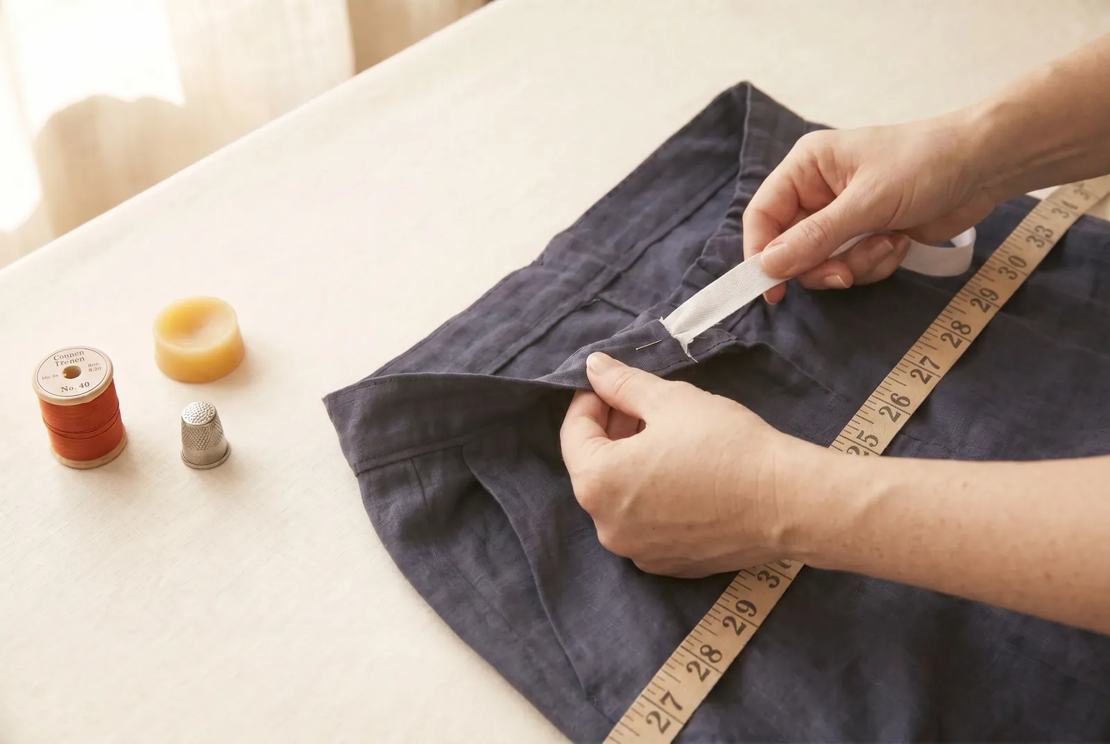 Photo: Hold the anchored end and pull the free end of the tape until the back gathers and the whole waistband equals the waist measurement from step 1.
