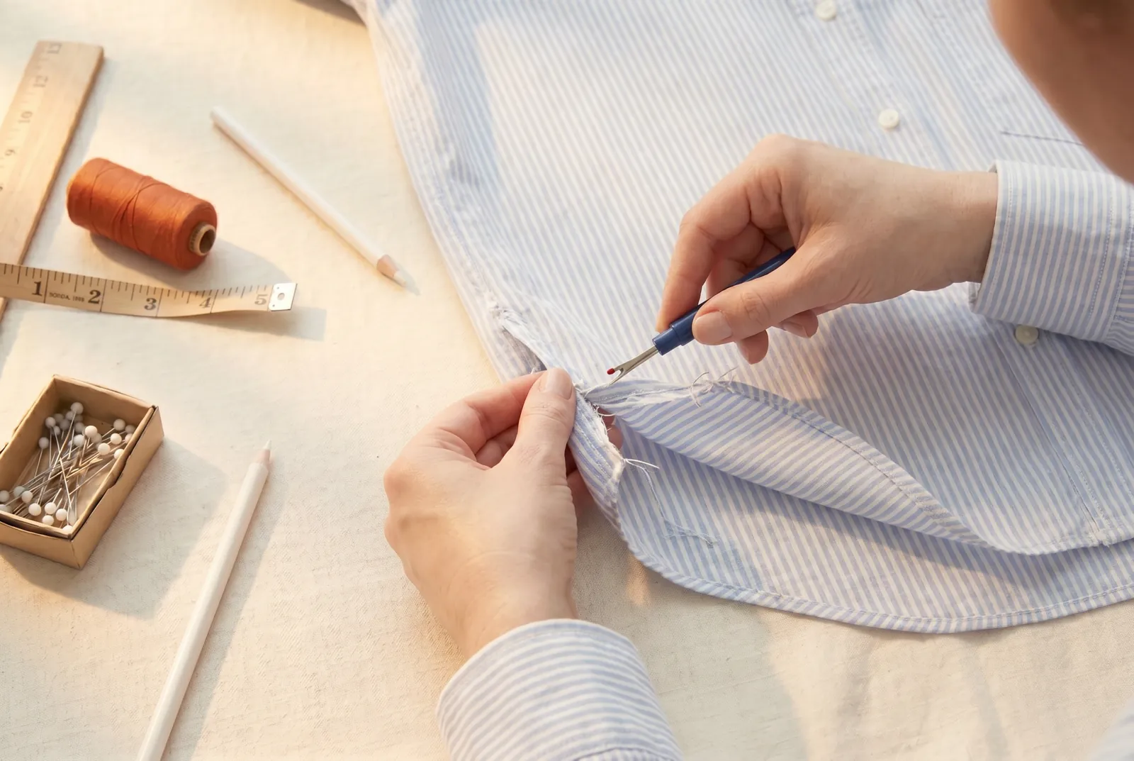 Photo: With the seam ripper, open the shirt's existing bottom hem for about 5 cm (2 in) on each side of each side seam.