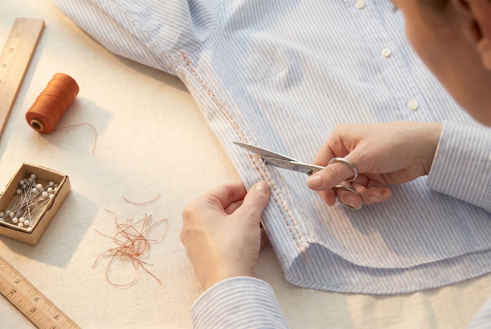 Photo: With the shirt right side out and the two cut edges held together, sew a line of small running stitches 3 mm (1/8 in) from the edge, from the hem to the join;…