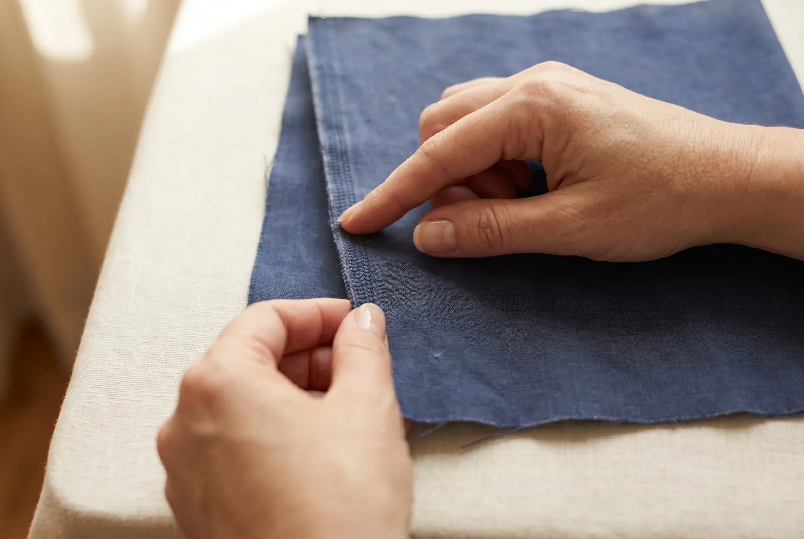 Photo: Lay the fabric flat and find a lengthwise edge that is firm and does not fray: this finished border is the selvage, formed where the crosswise threads turn bac…