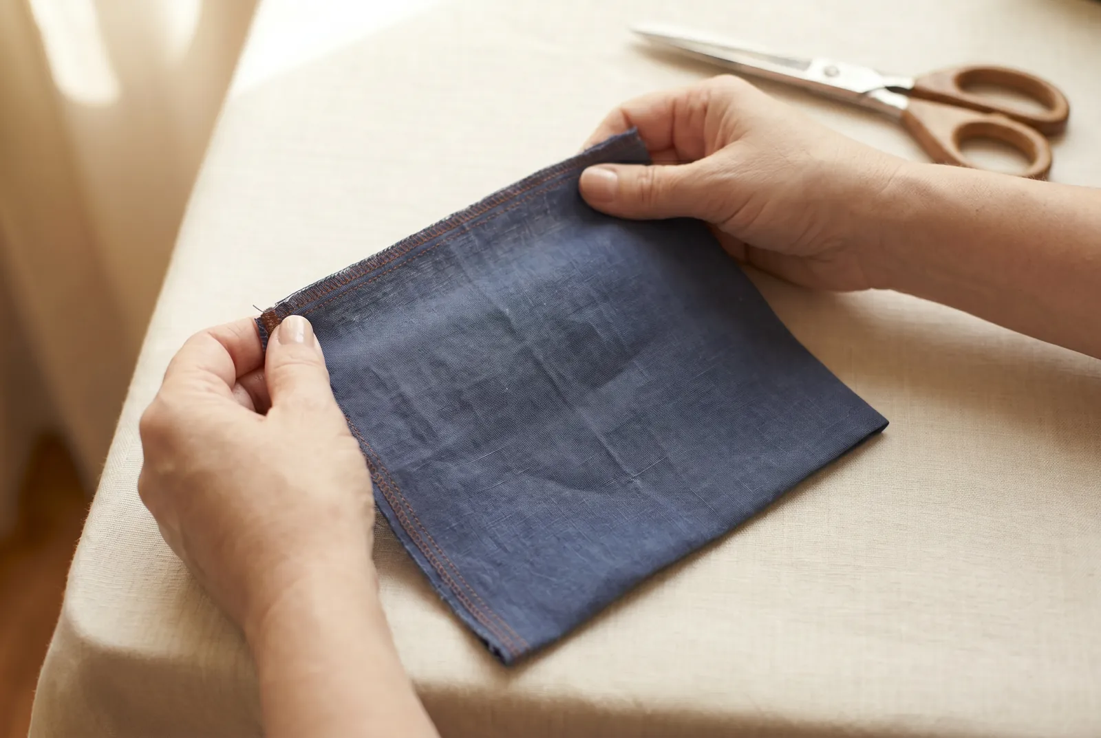 Photo: Hold the fabric with both hands about a hand-span apart and pull gently along the length, parallel to the selvage: it barely gives.
