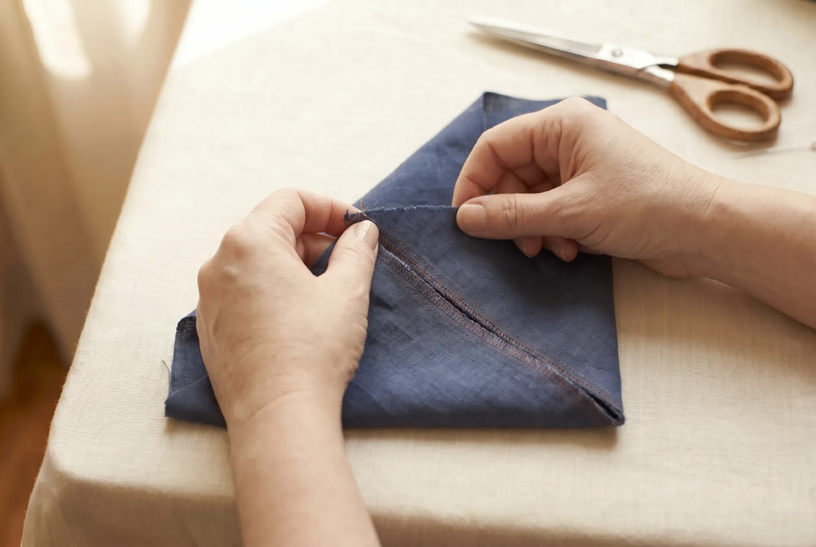 Photo: To locate the true bias exactly instead of by eye, fold the cloth so that a straightened crosswise end lies along the selvage.