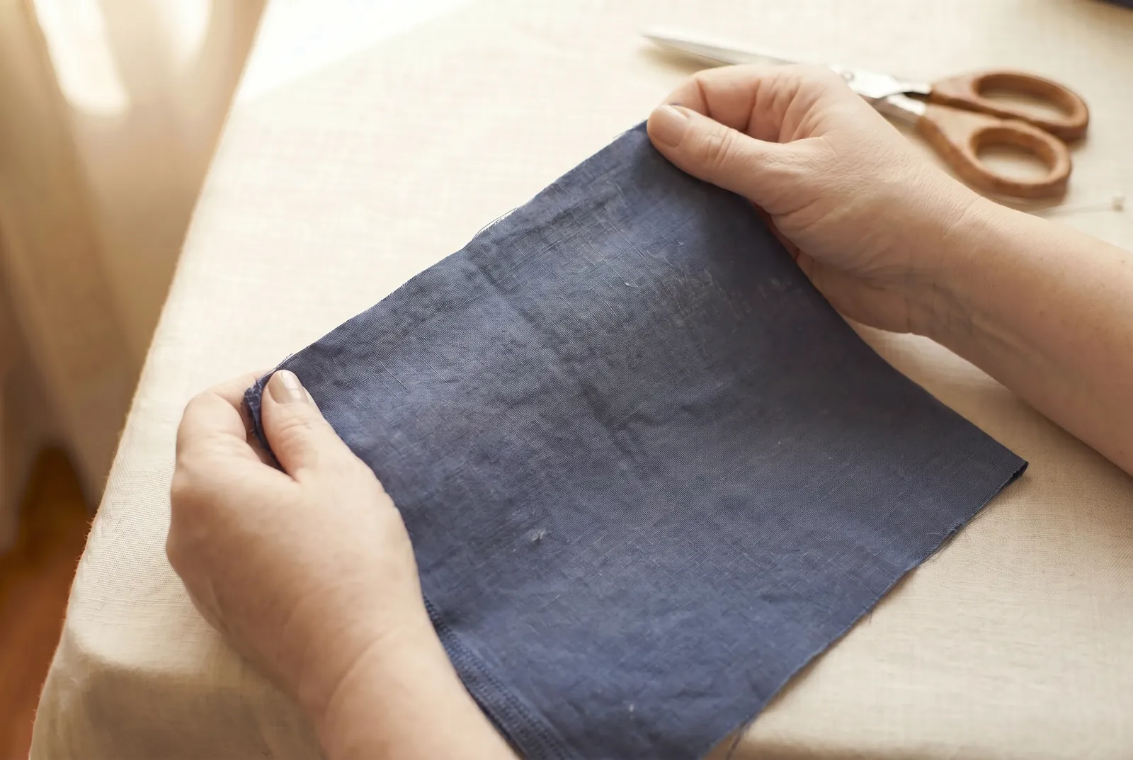 Photo: If your fabric has been folded or balled up off grain, pull it back true before cutting: take the short corners and stretch the cloth gently on the bias until…