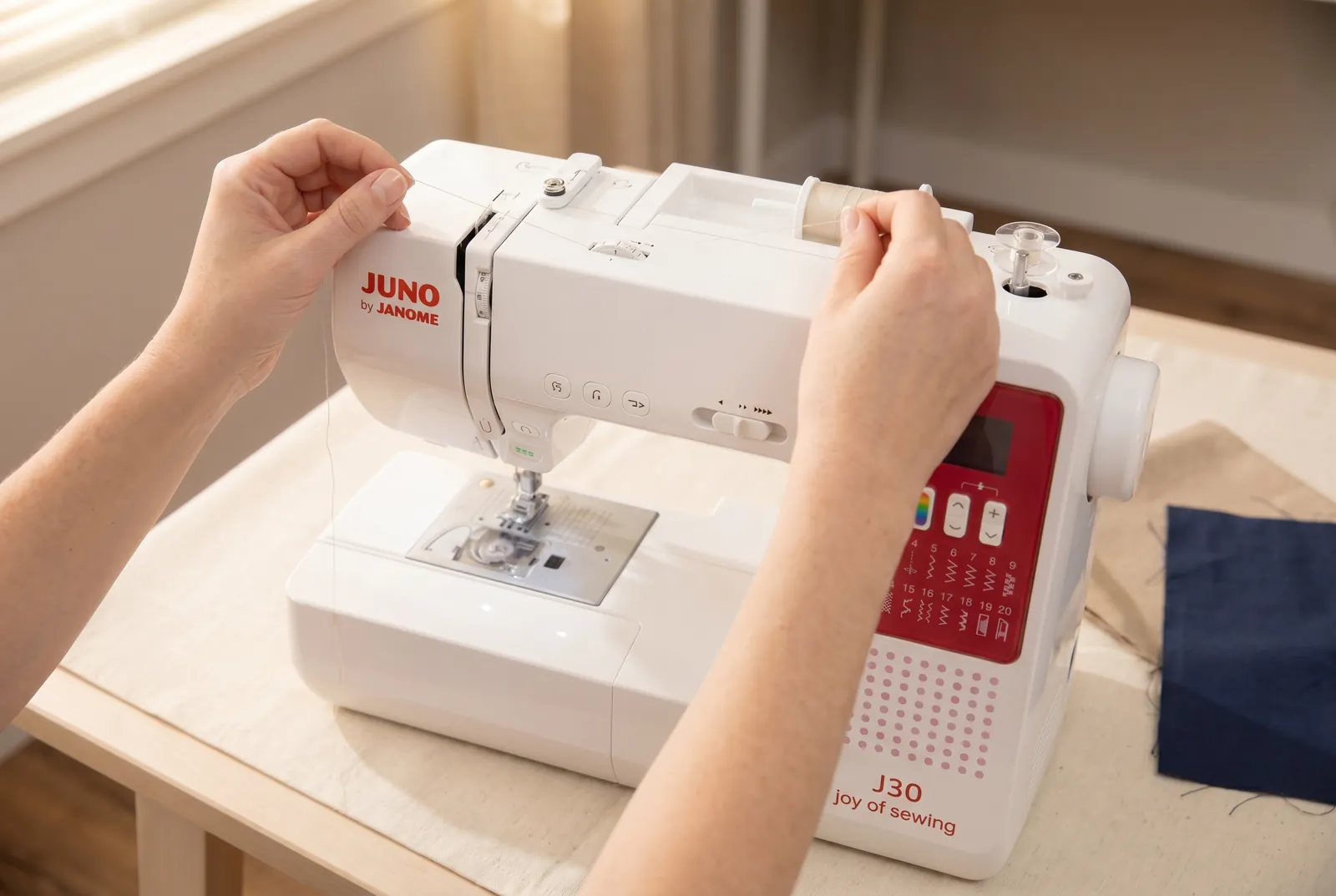 Photo: Follow the printed thread-guide path from the spool pin to the bobbin winder, a second, smaller pin near the top right of the machine.
