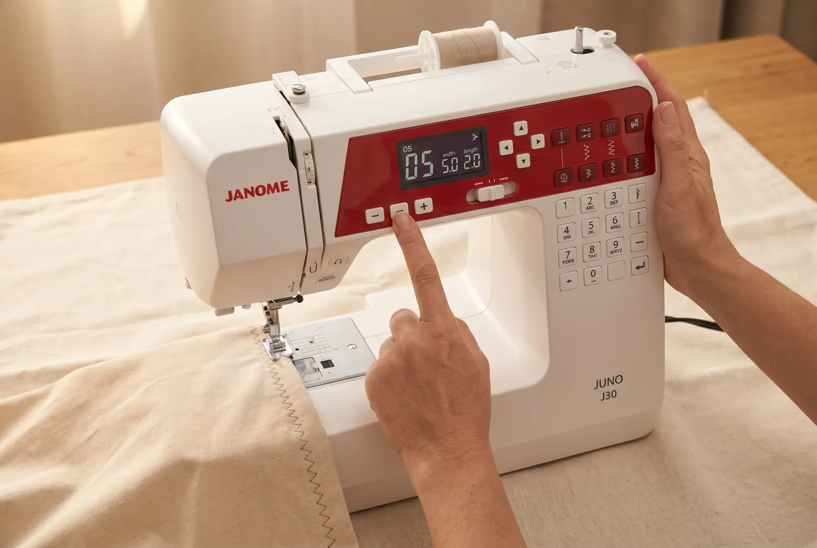 Photo: Use the +/- buttons to select the zigzag stitch program from the stitch chart on the front panel.